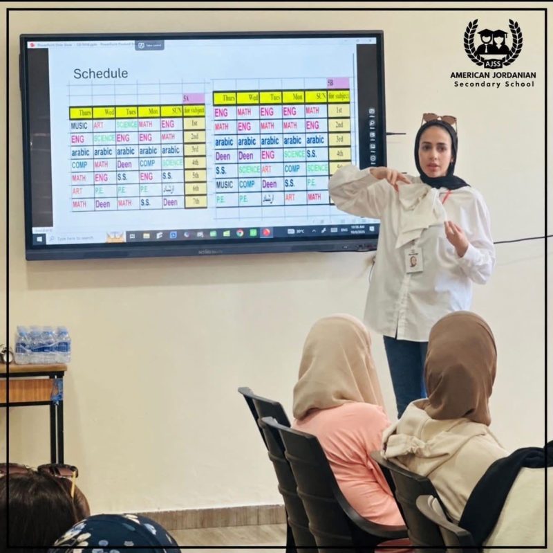 A teacher presents the class timetable on screen at an orientation session