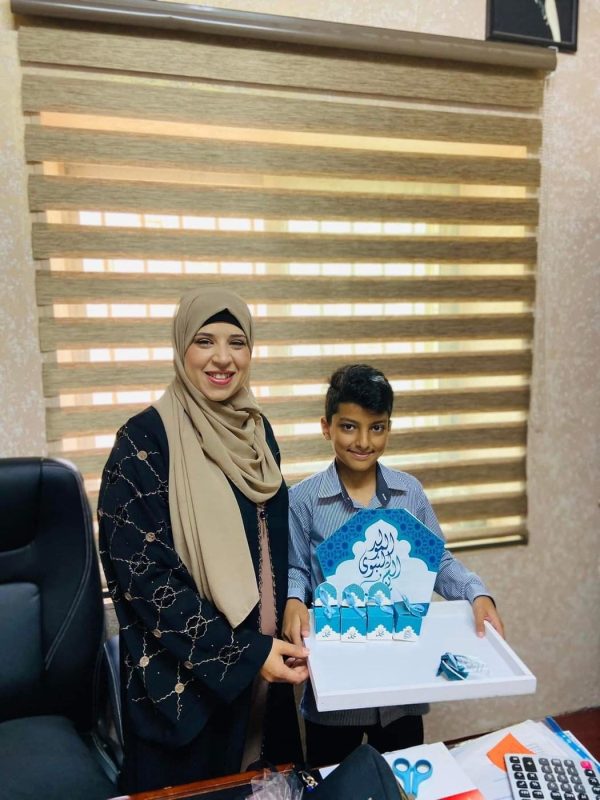 A staff member and a student hold a presentation box in the school office